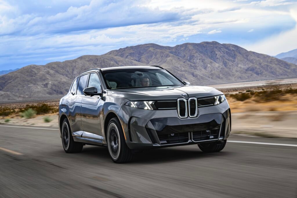 A BMW iX5 drives on the road.