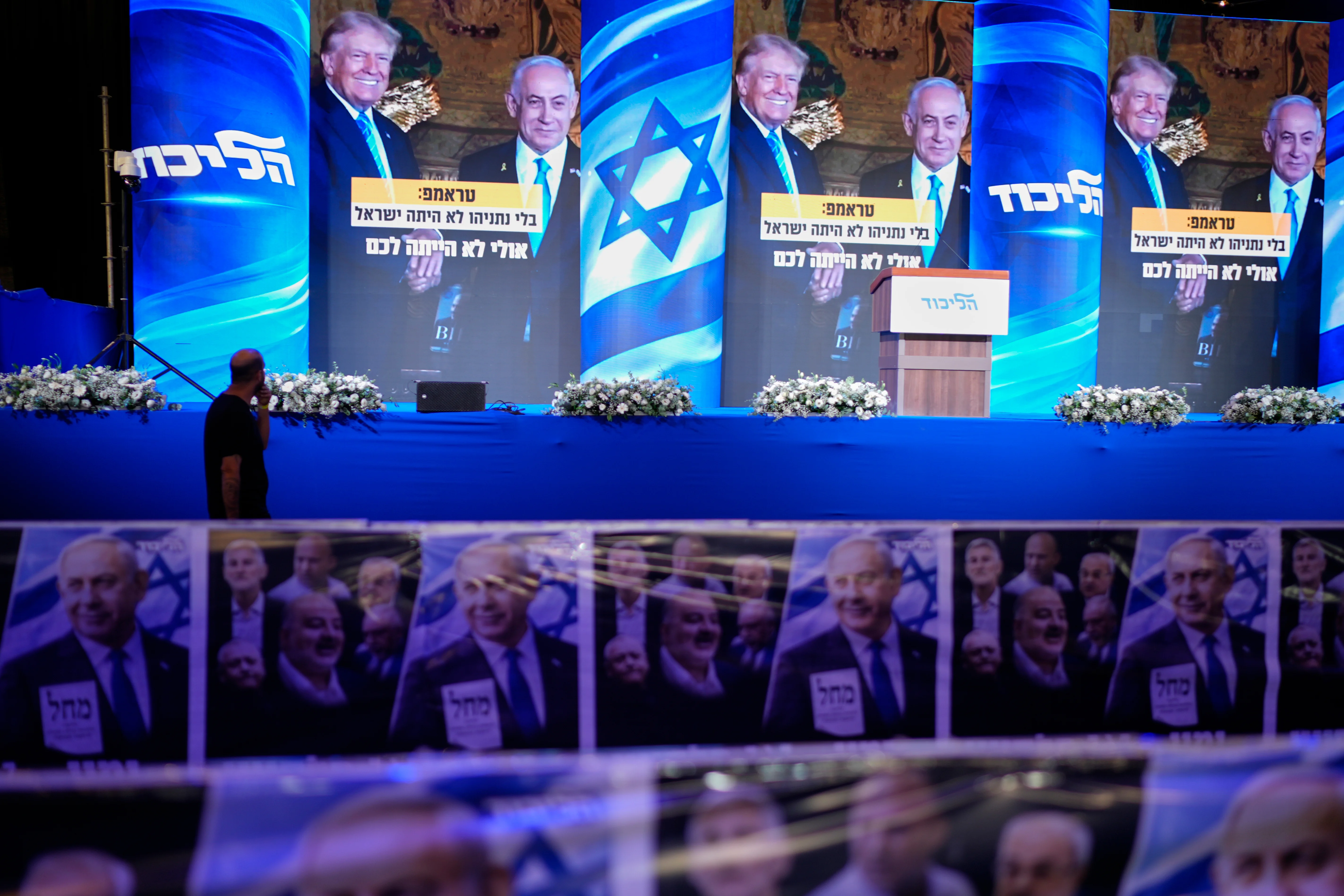 A video wall displays images of Benjamin Netanyahu with President Trump at a Likud party event before the release of the first exit poll results in Israel