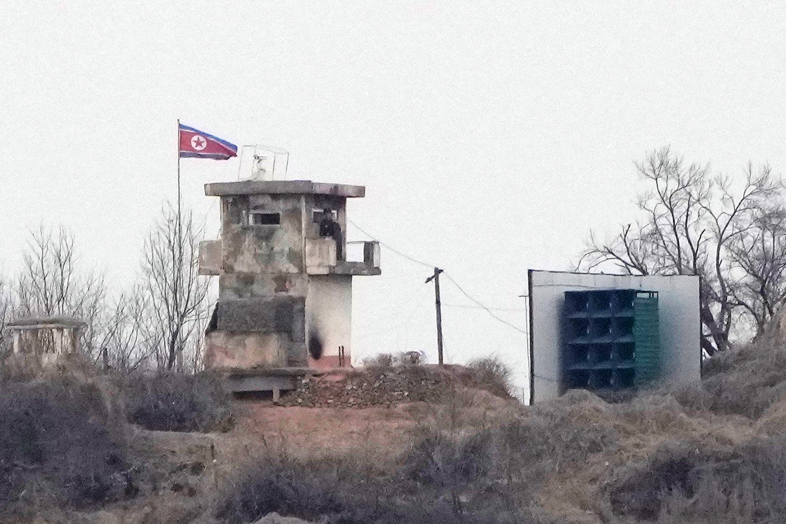 FILE - A soldier stands at a North Korean military guard post next to loudspeakers, seen from Paju, South Korea, near the border with North Korea, on Feb. 26, 2026.