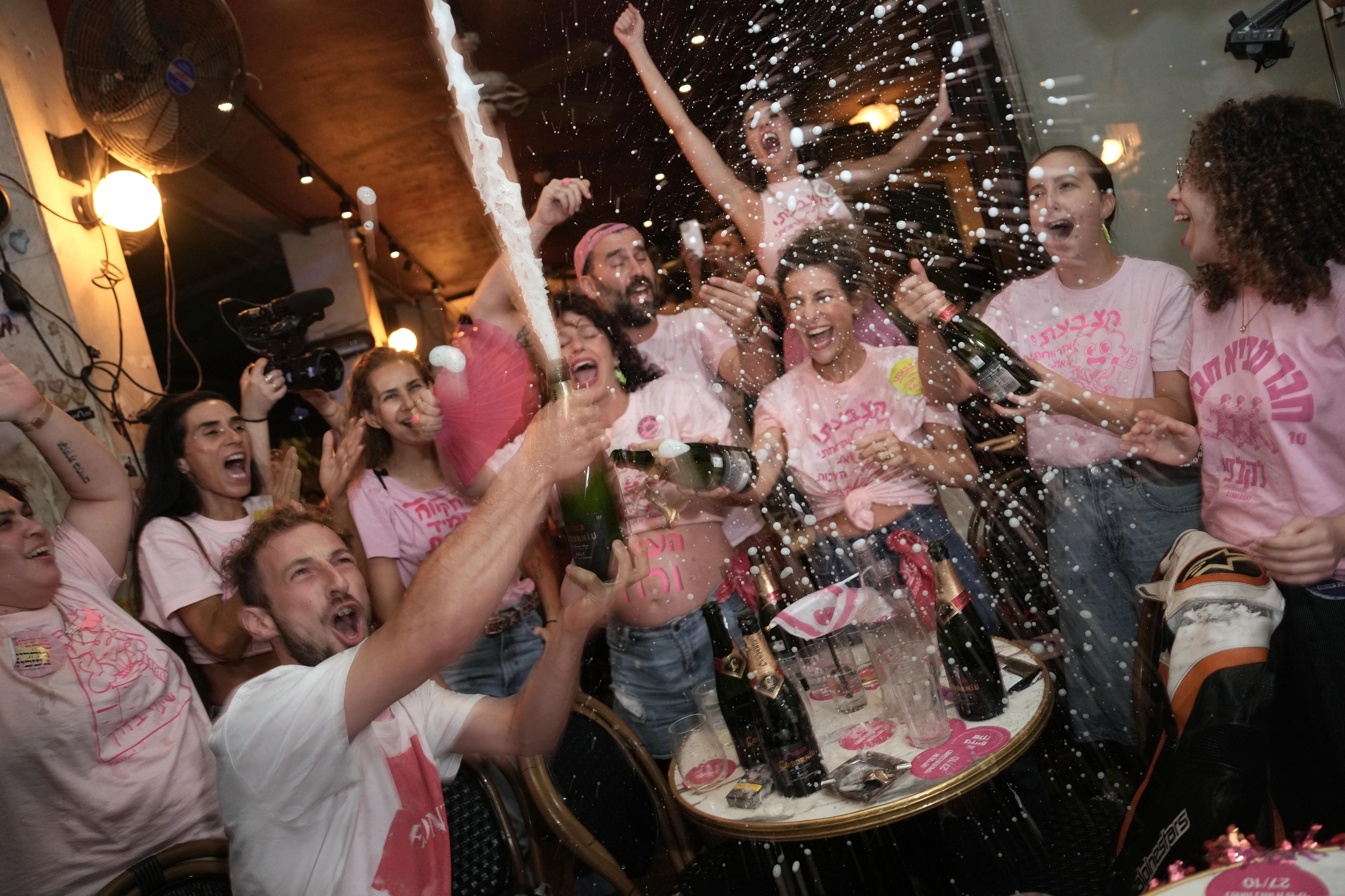 People spray sparkling wine as they celebrate early exit poll results for Israel