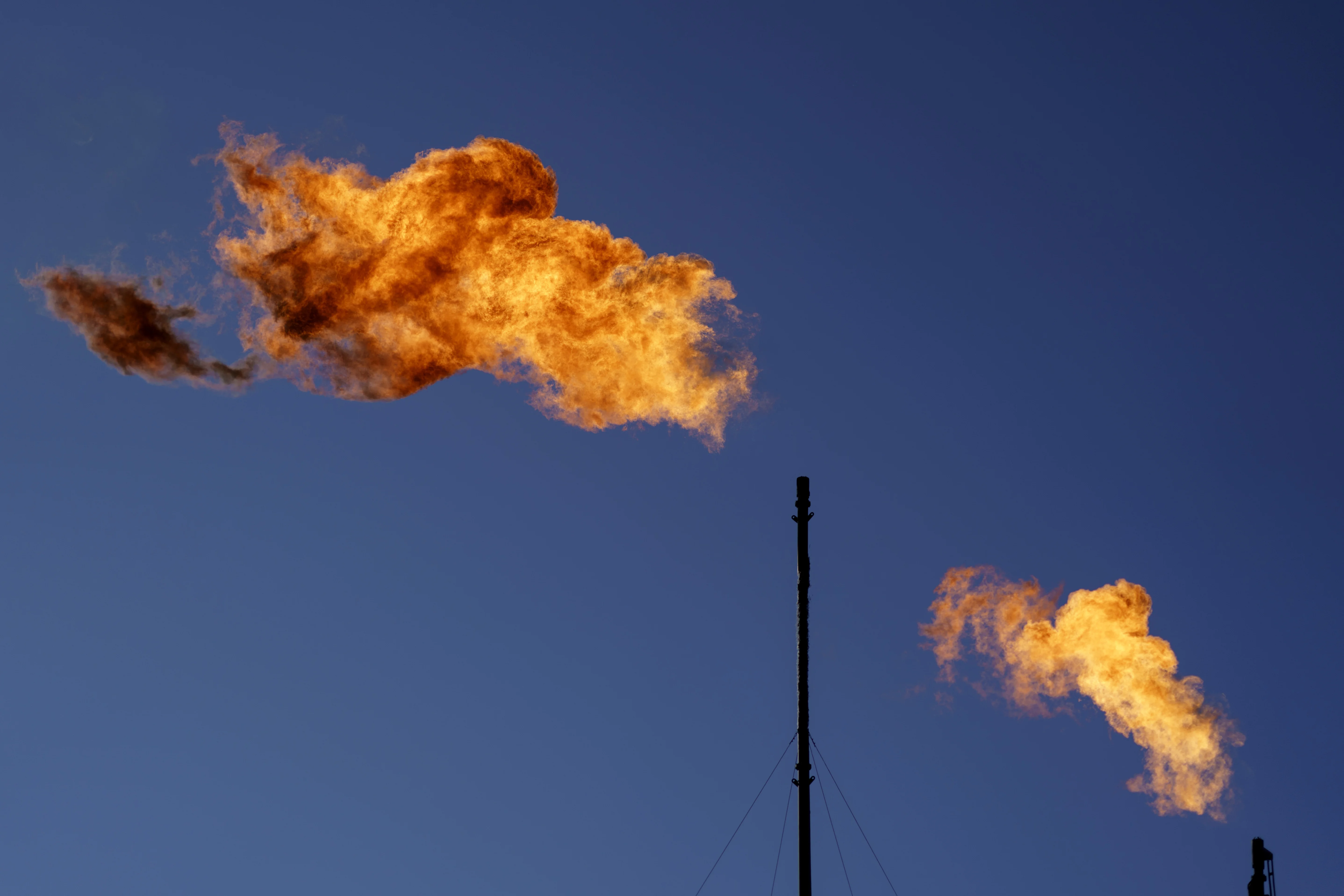 Flares burn off methane and other hydrocarbons at an oil and gas facility in Lenorah, Texas, Oct. 15, 2021.