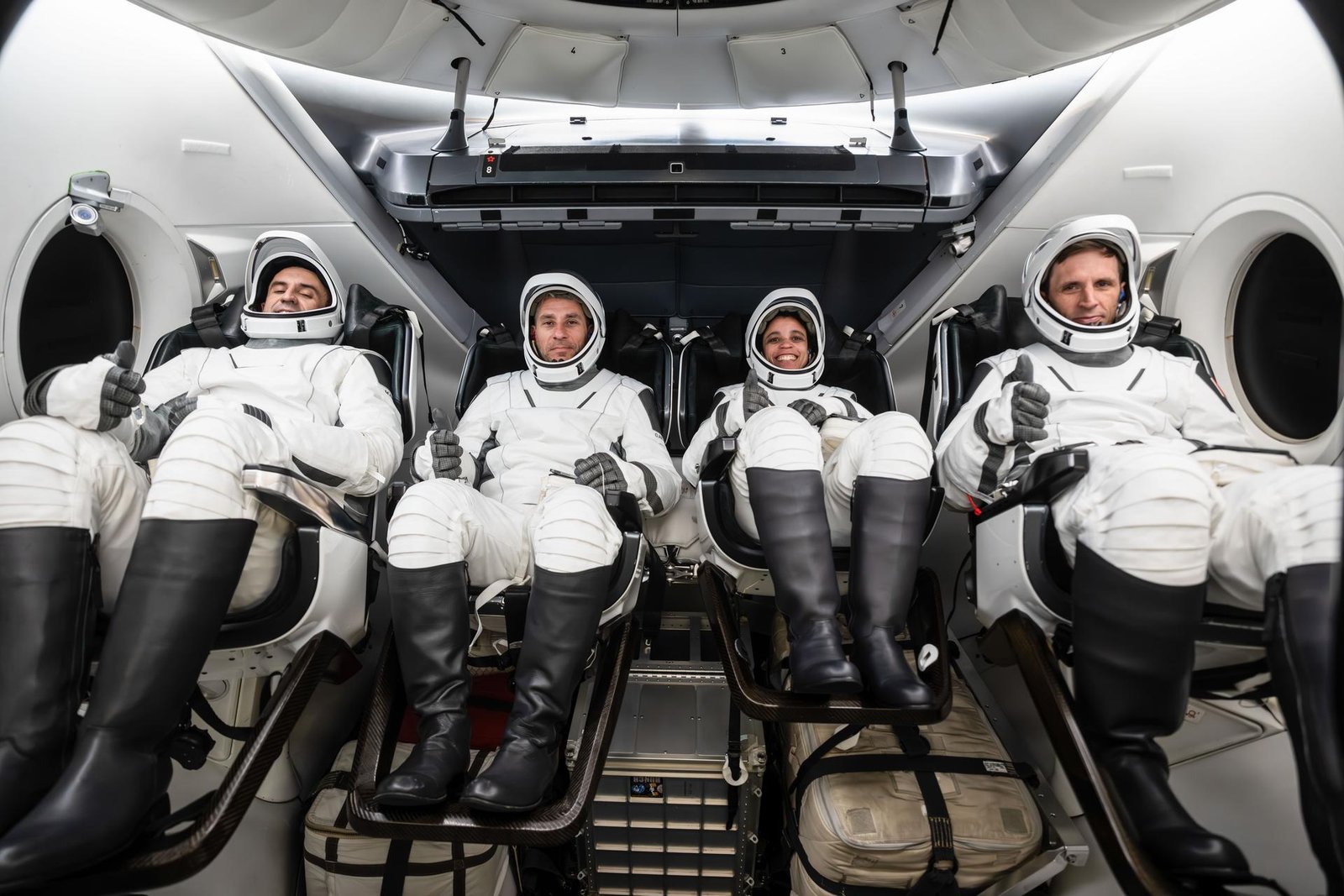 The SpaceX Crew-13 members are pictured in their pressure suits seated inside a mockup Dragon spacecraft during a preflight training session at the company's headquarters in Hawthorne, California. From left are, Roscosmos Sergey Teteryatnikov, NASA astronauts Luke Delaney and Jessica Watkins, and CSA (Canadian Space Agency) astronaut Joshua Kutryk.