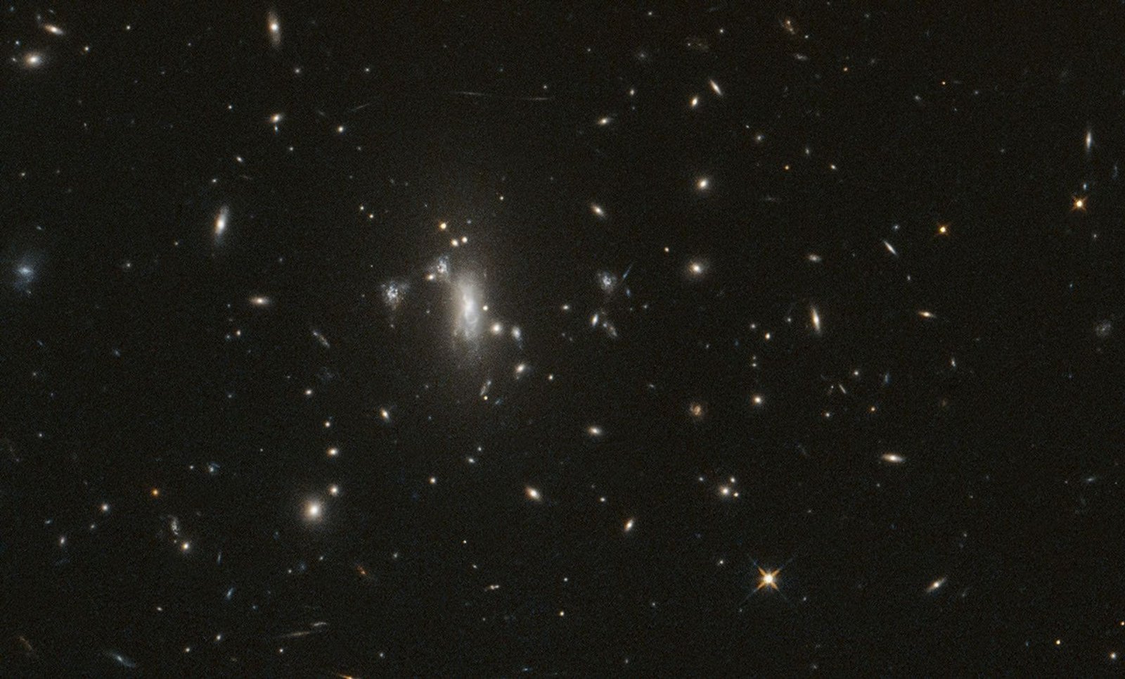 Several galaxies shine against black space, with a large cluster near center-left.